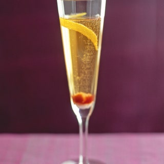 Champagne cocktail in a sparkling wine flute with bitterssoaked sugar cube and lemon twist.