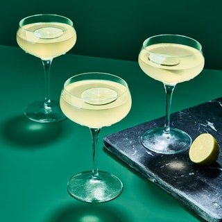 Three gimlet cocktails in coupes with lime wheels.