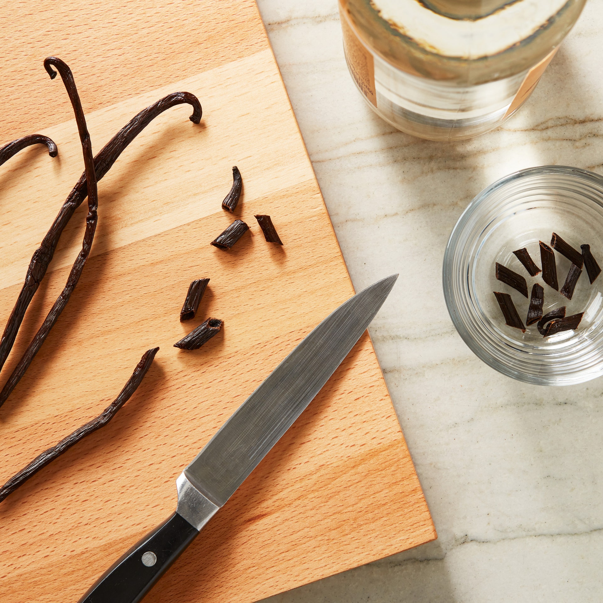 Cutting a vanilla bean on a cutting board.
