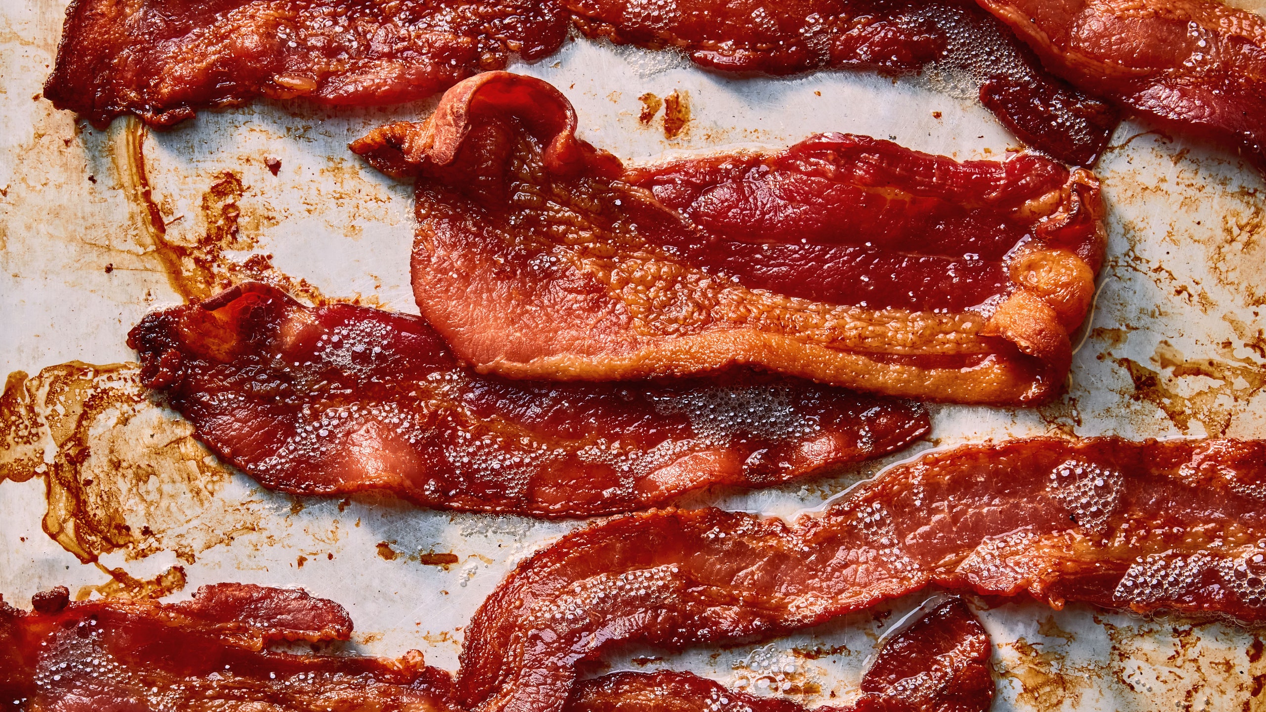 Strips of crispy bacon on a baking sheet.