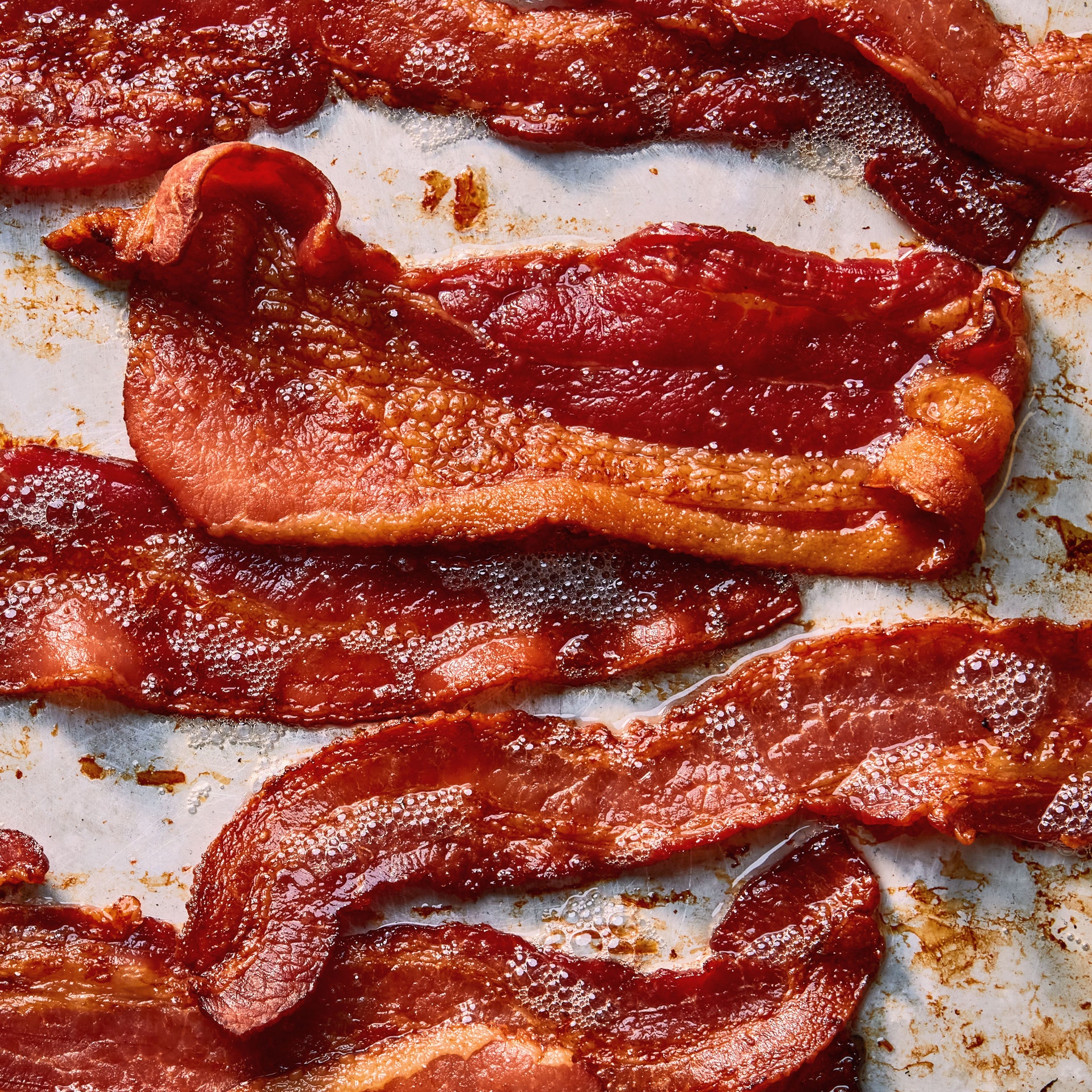 Strips of crispy bacon on a baking sheet.