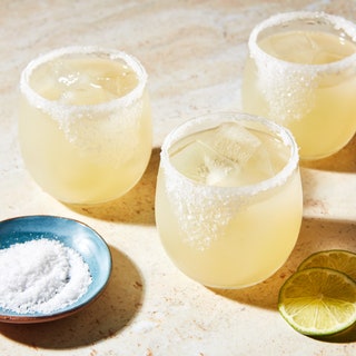 Three margarita cocktails in glasses with salted rims.