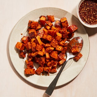 A plate of roasted sweet potato pieces with a spiced maple glaze.