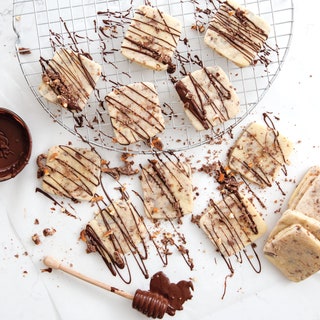 Bespeckled square cookies with a chocolate drizzle.