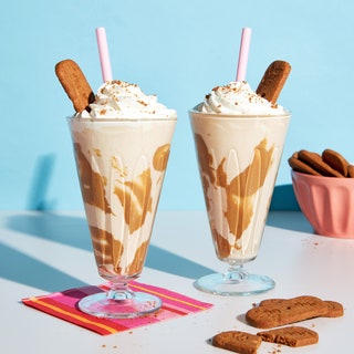 Two frapp glasses lined with cookie butter and filled with vanilla ice cream malted milk powder whipped cream and topped...